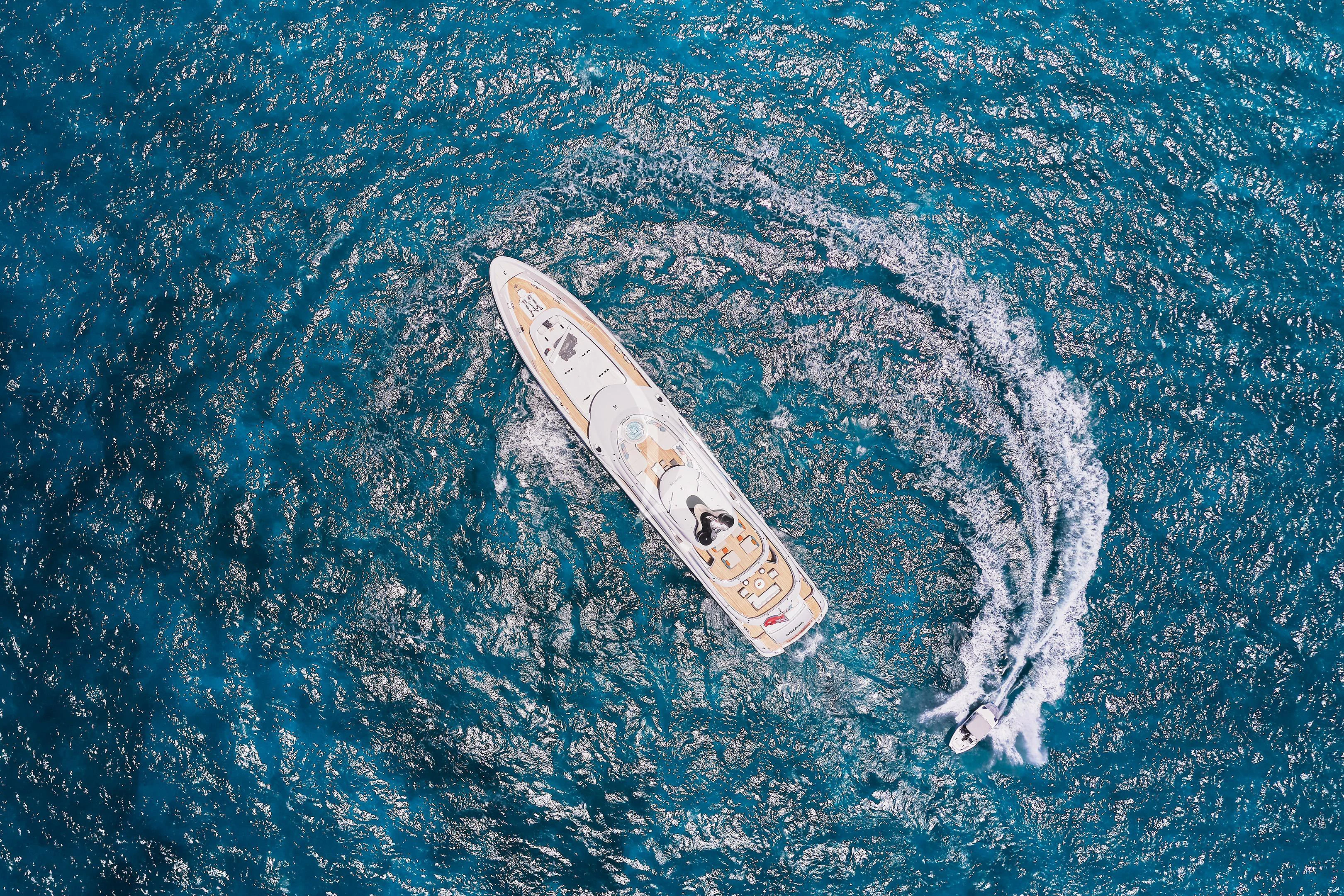 a white surfboard in the ocean aboard ARKADIA Yacht for Charter