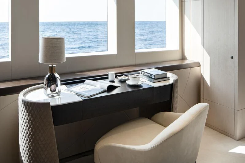 a desk with a lamp and a window aboard ARKADIA Yacht for Charter