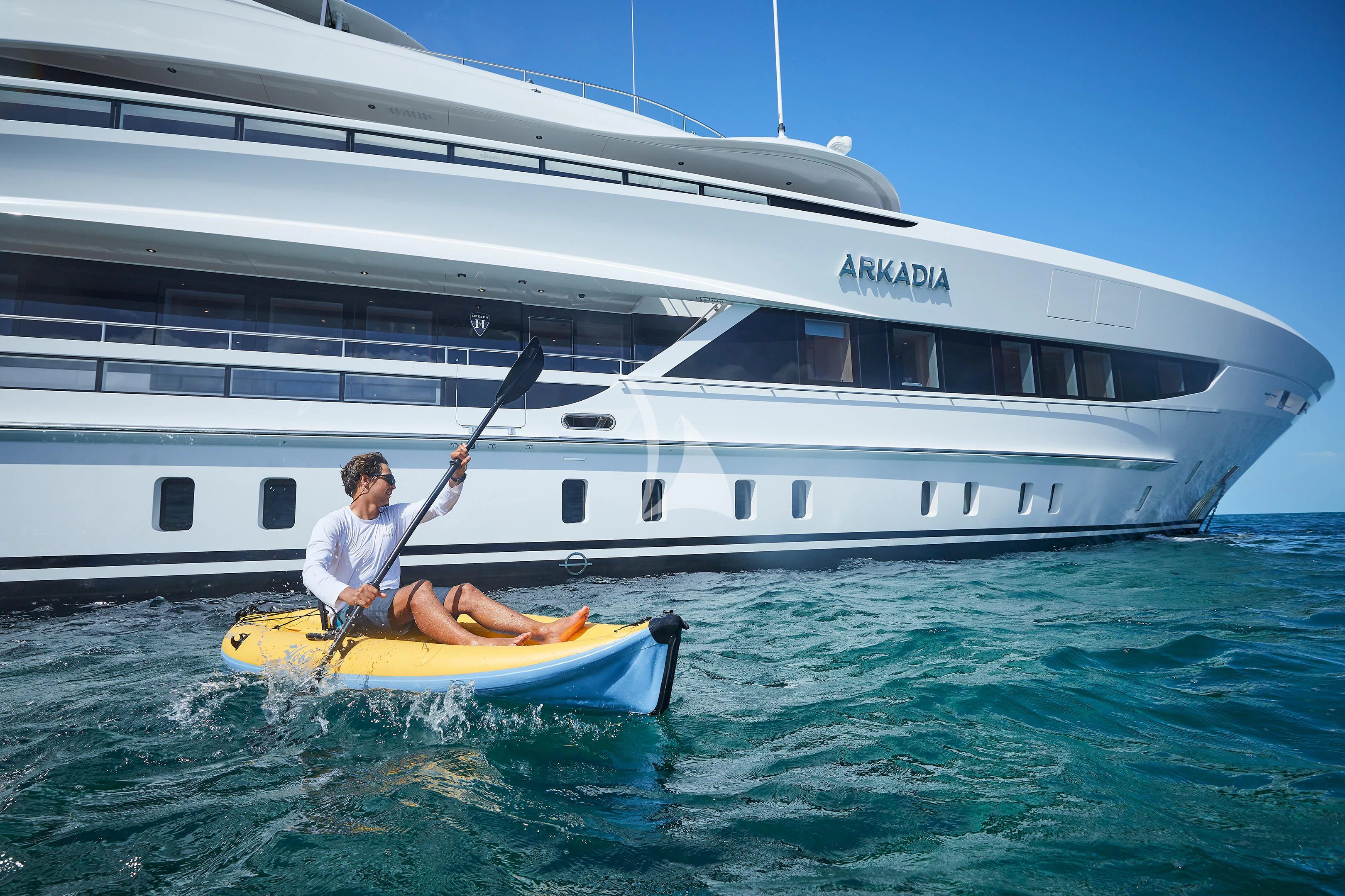 a person on a paddle board in front of a boat aboard ARKADIA Yacht for Charter