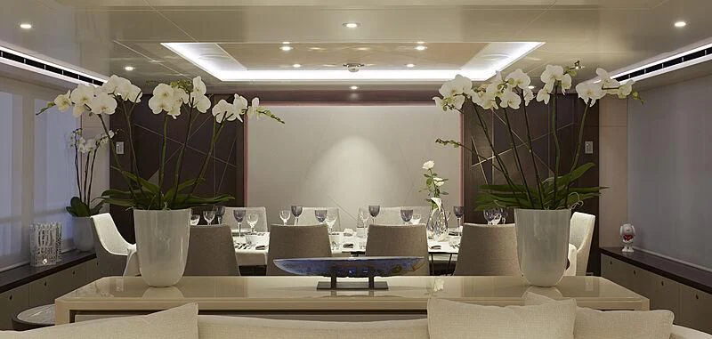 a table with vases of white flowers on it aboard ARKADIA Yacht for Charter