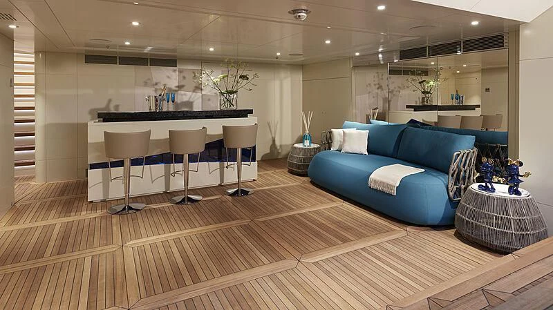 a living room with a blue couch aboard ARKADIA Yacht for Charter