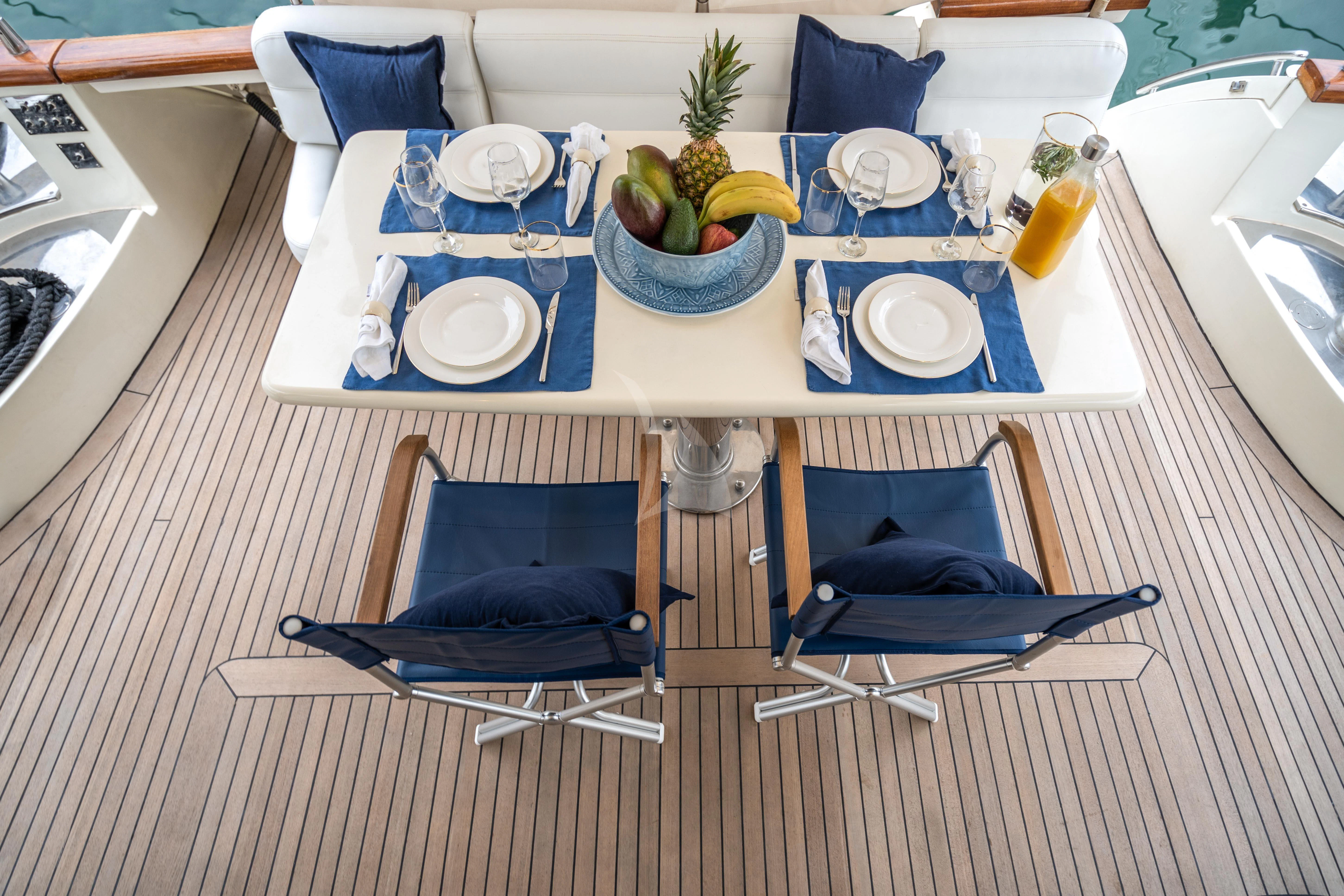 a table with plates and fruit on it aboard ESTIA ZEUS Yacht for Charter