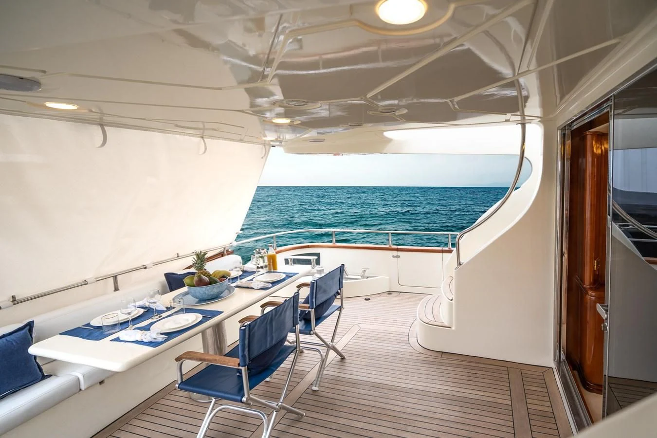 a room with a table chairs and a pool aboard ESTIA ZEUS Yacht for Charter