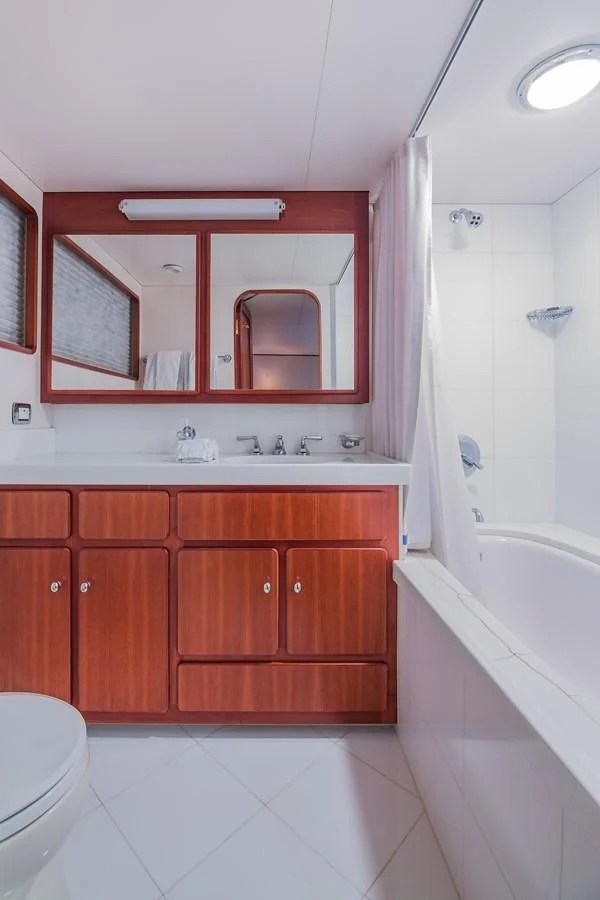 a bathroom with a tub sink and cabinets aboard CASUAL WATER Yacht for Sale