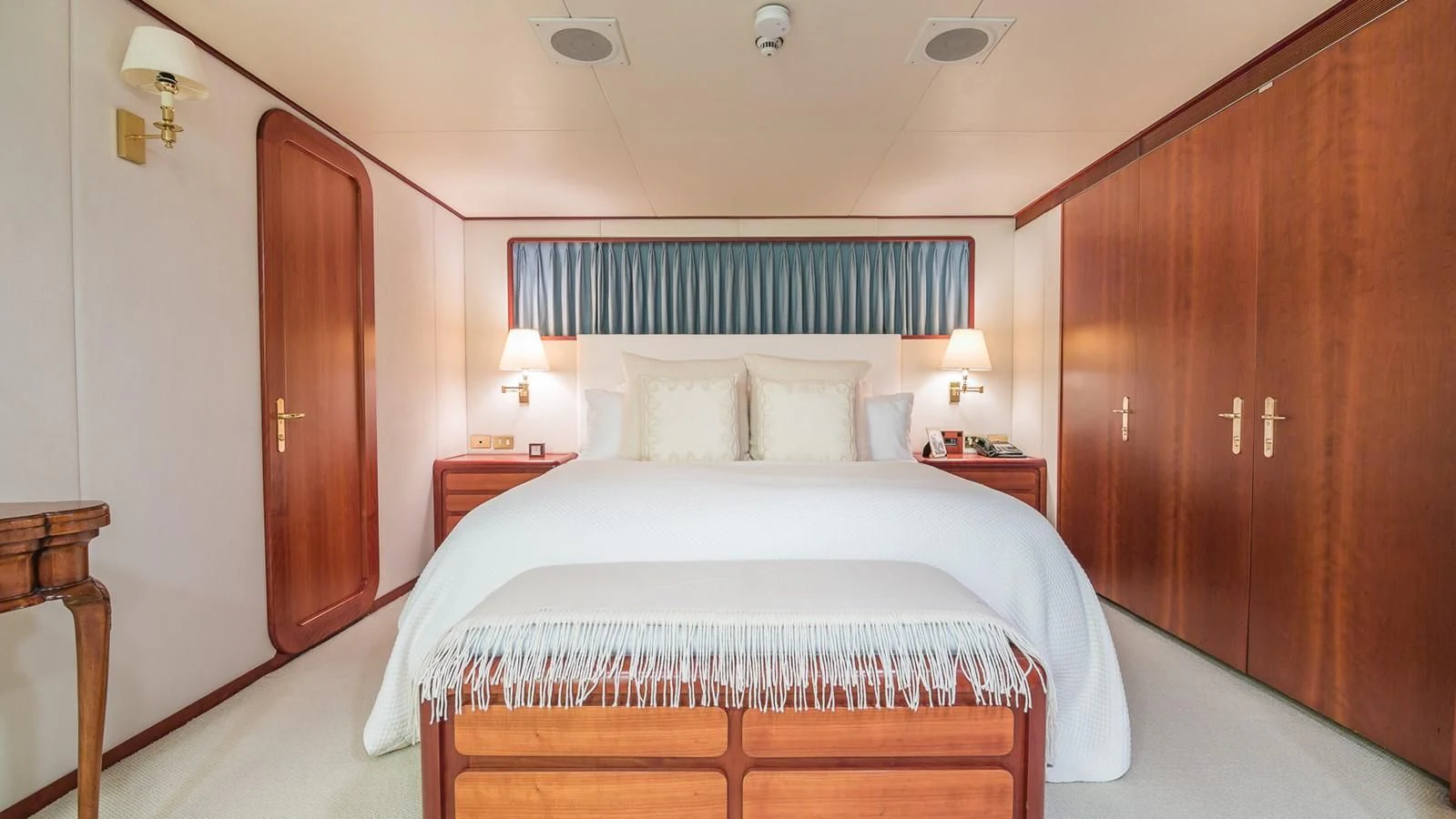 a bedroom with a bed and a wood door aboard CASUAL WATER Yacht for Sale
