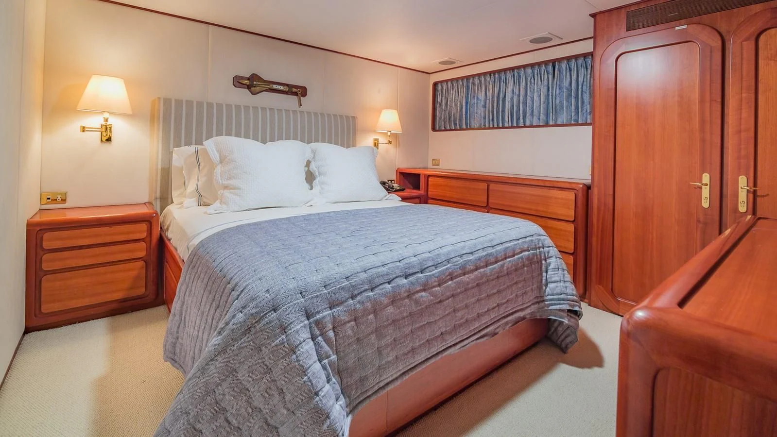 a bedroom with a bed and a dresser aboard CASUAL WATER Yacht for Sale