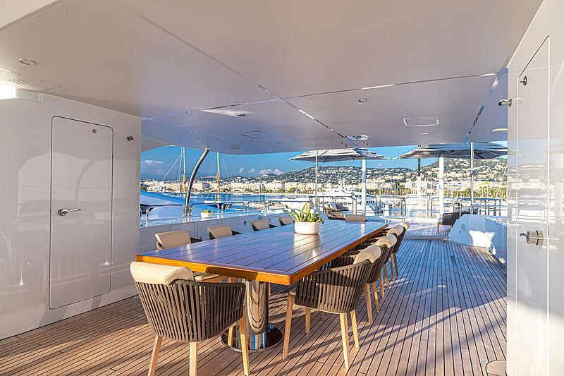 a table and chairs on a deck aboard BOMBAY Yacht for Sale