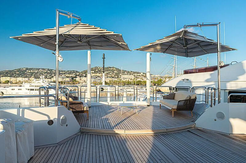 a deck with a couple of white boats and umbrellas on it aboard BOMBAY Yacht for Sale
