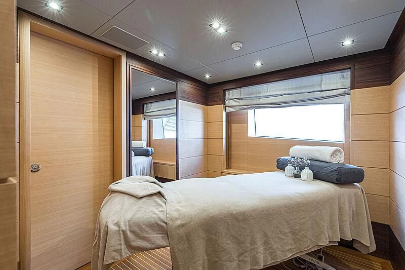 a bedroom with a bed and a window aboard BOMBAY Yacht for Sale