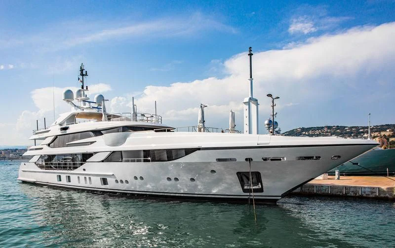 a large white boat docked at a pier aboard BOMBAY Yacht for Sale