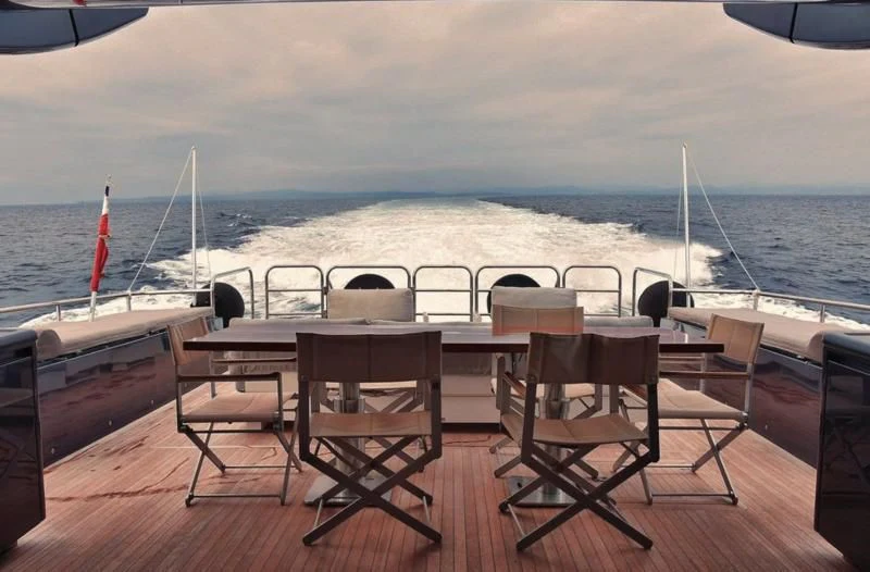 a table and chairs on a deck overlooking a body of water aboard DARK KNIGHT Yacht for Sale