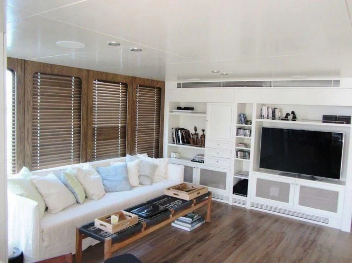 a living room with a tv and a table aboard LUTTEUR Yacht for Sale