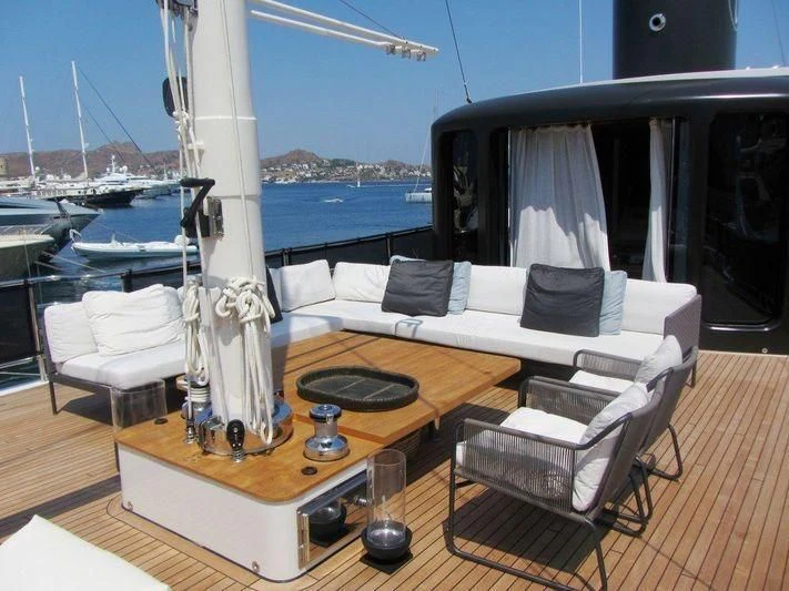 a room with a couch and a table with chairs on it aboard LUTTEUR Yacht for Sale