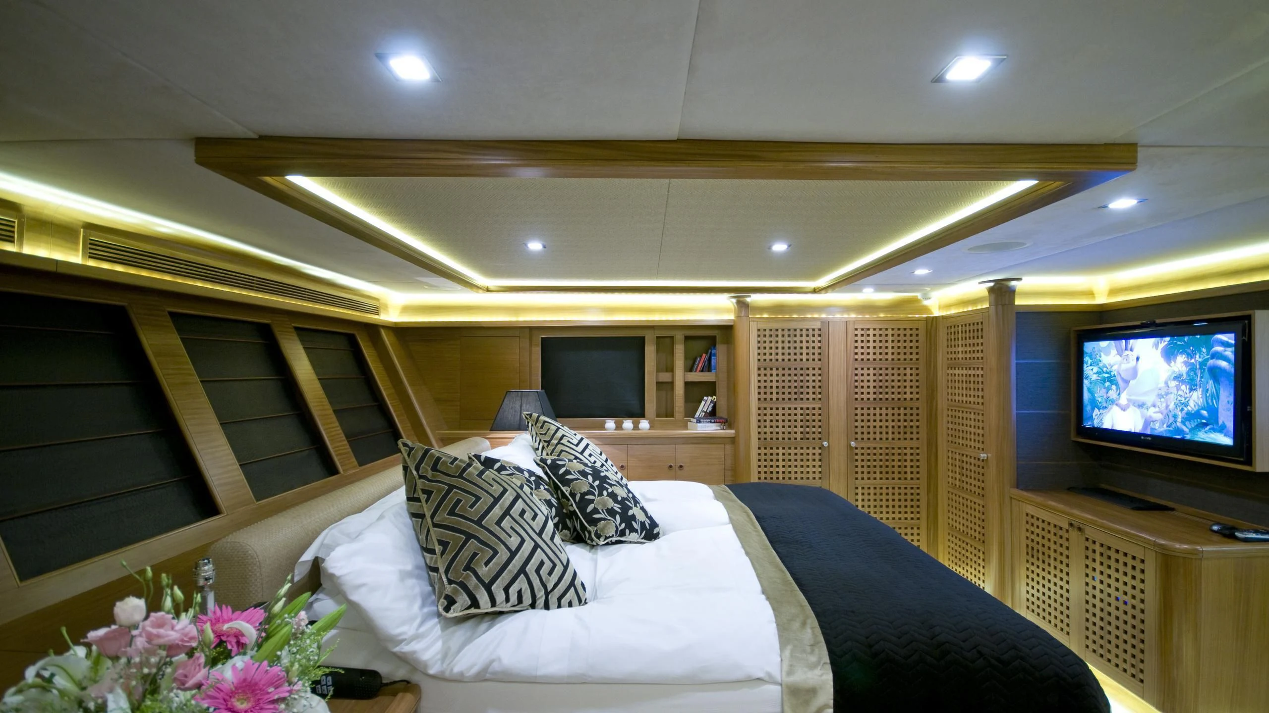 a bedroom with a bed and a television aboard DAIMA Yacht for Sale