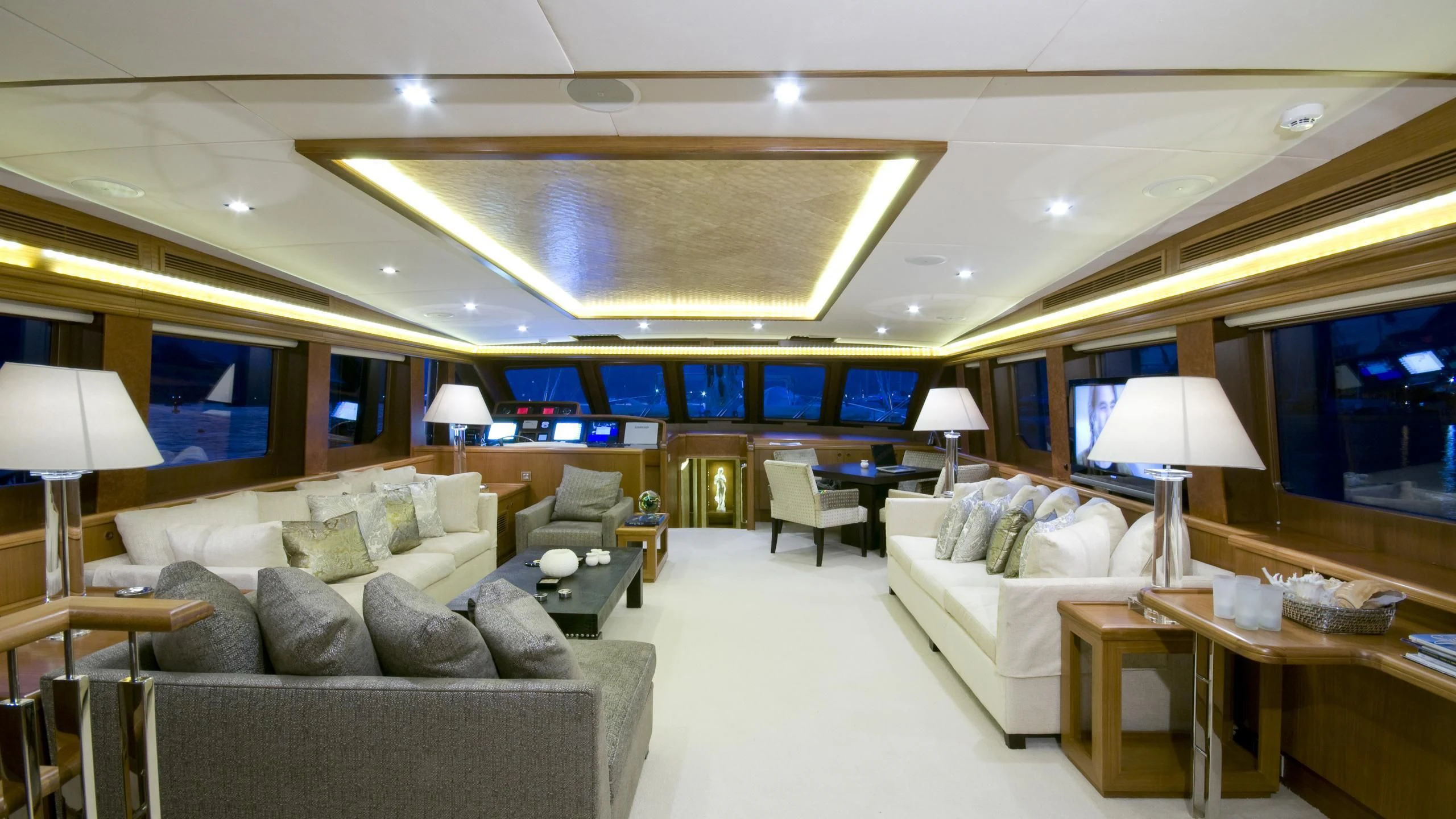 a living room with a large couch and a large mirror aboard DAIMA Yacht for Sale
