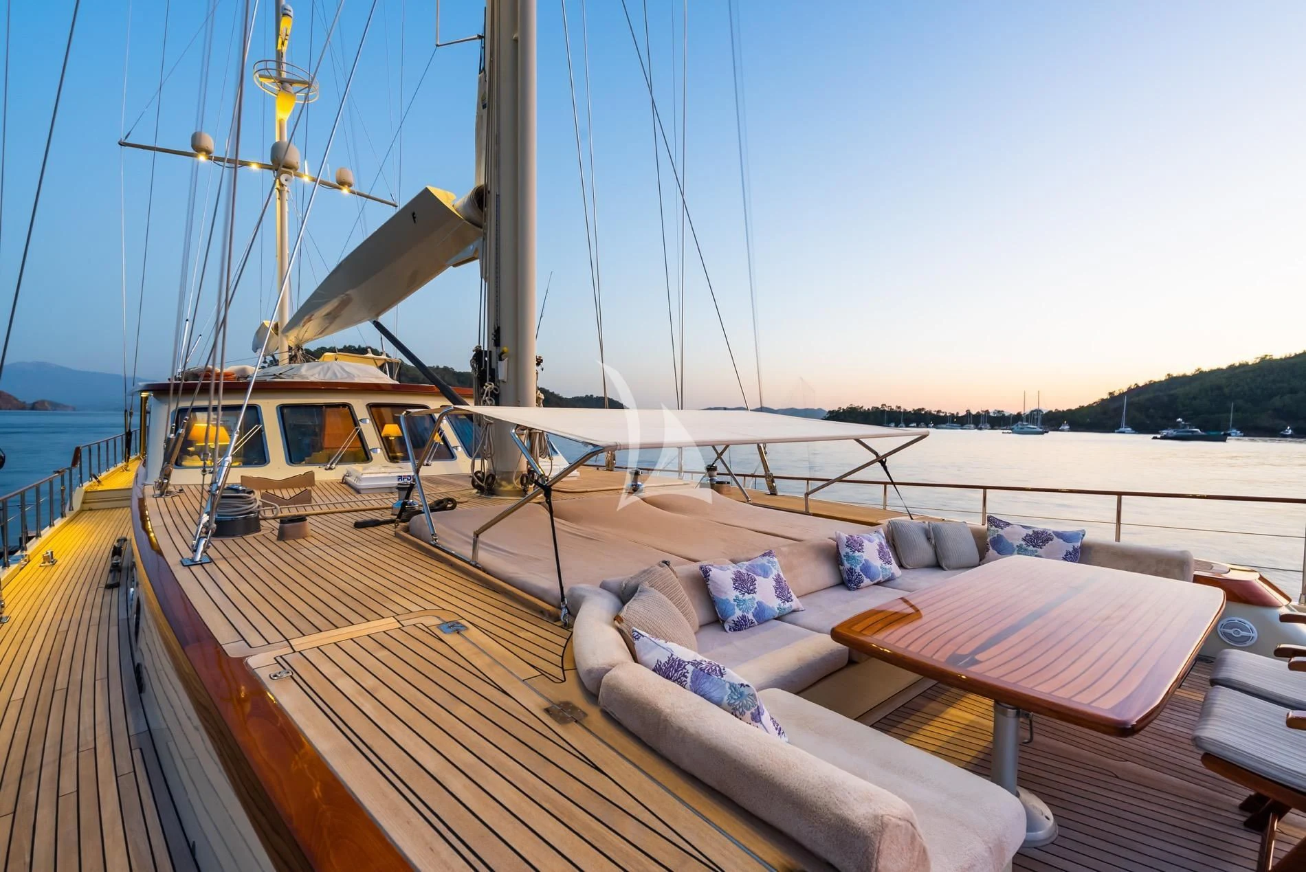 a deck with a couch and a boat on it aboard DAIMA Yacht for Sale