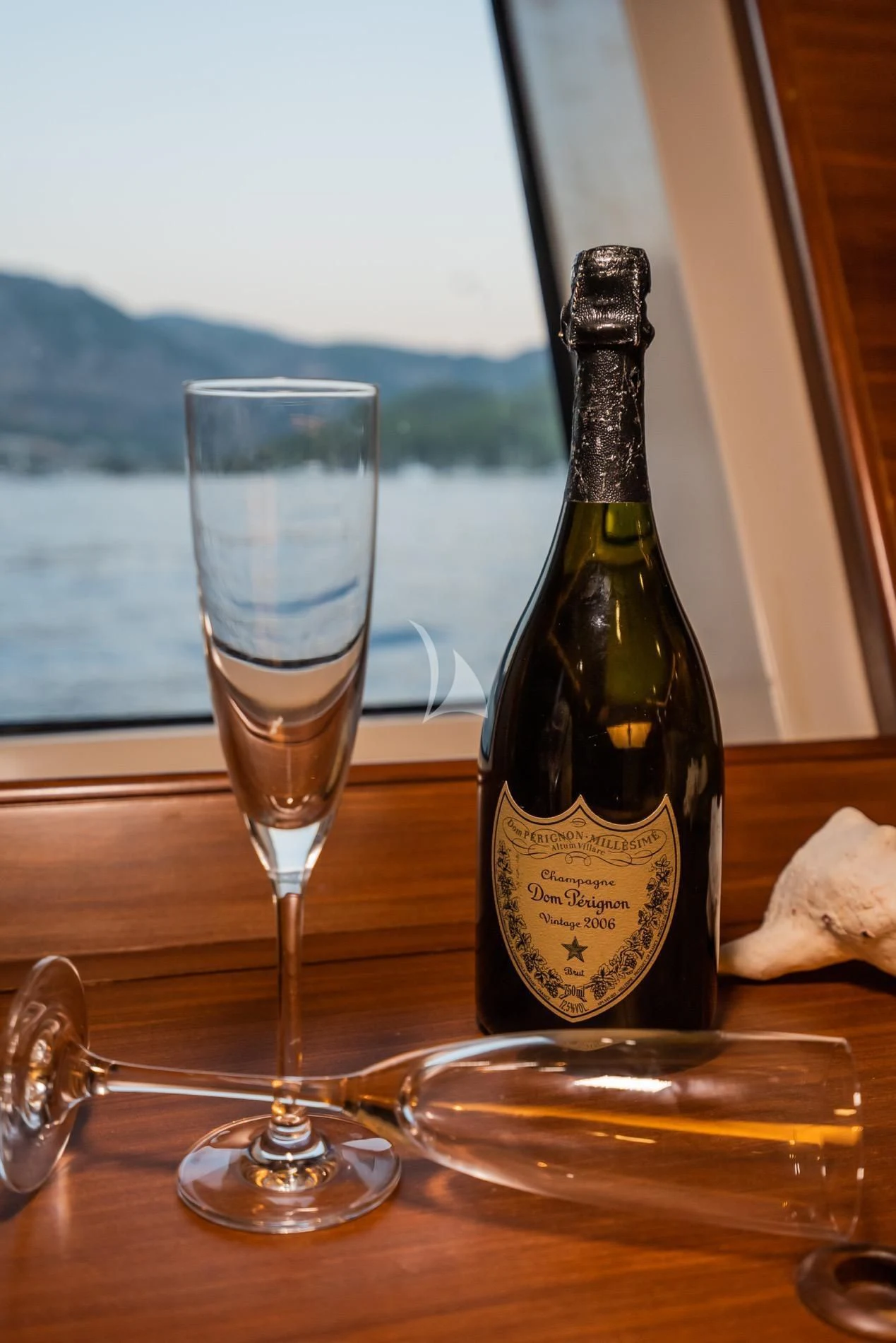 a bottle of wine next to a glass of wine aboard DAIMA Yacht for Sale
