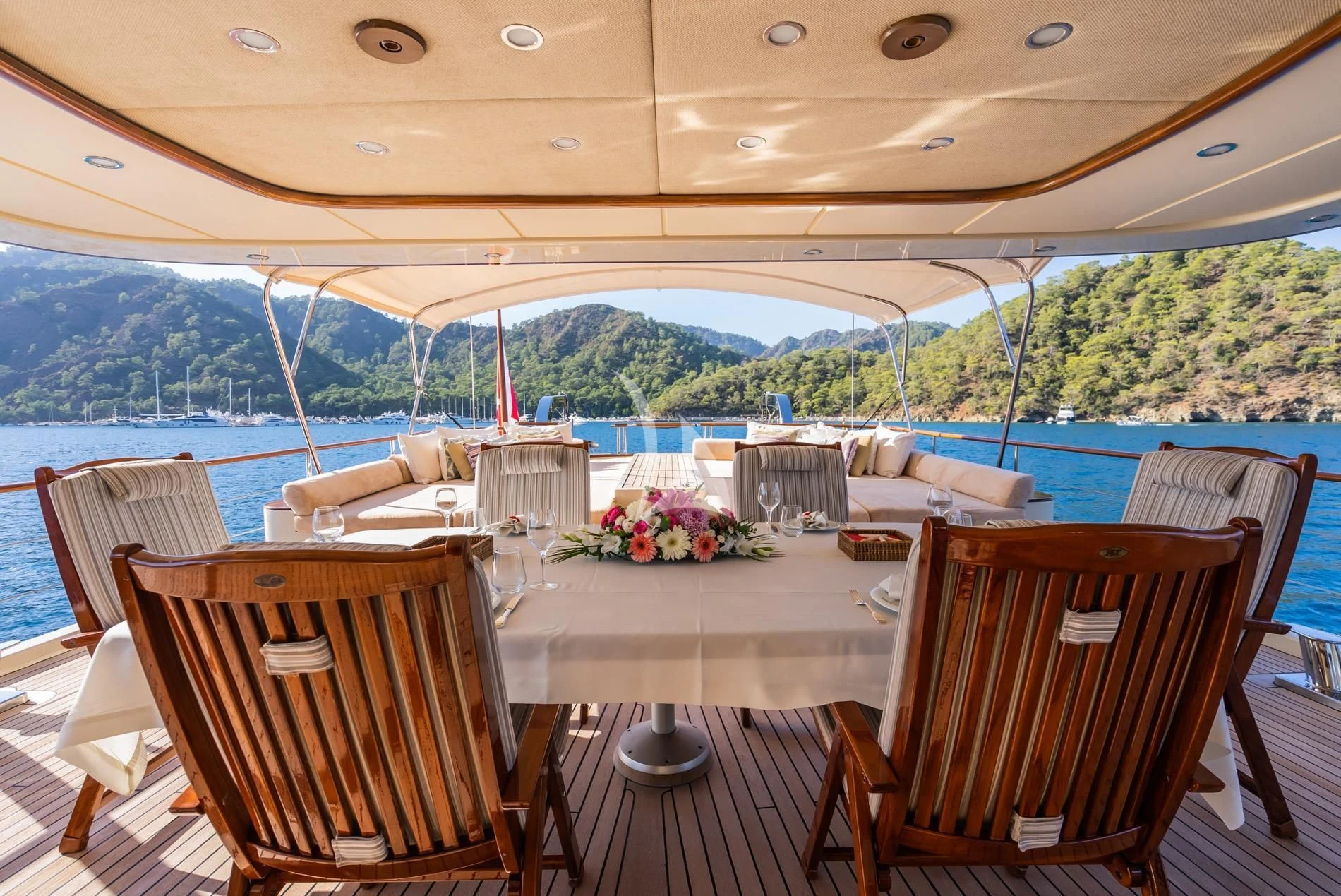 a table and chairs on a deck overlooking a body of water aboard DAIMA Yacht for Sale