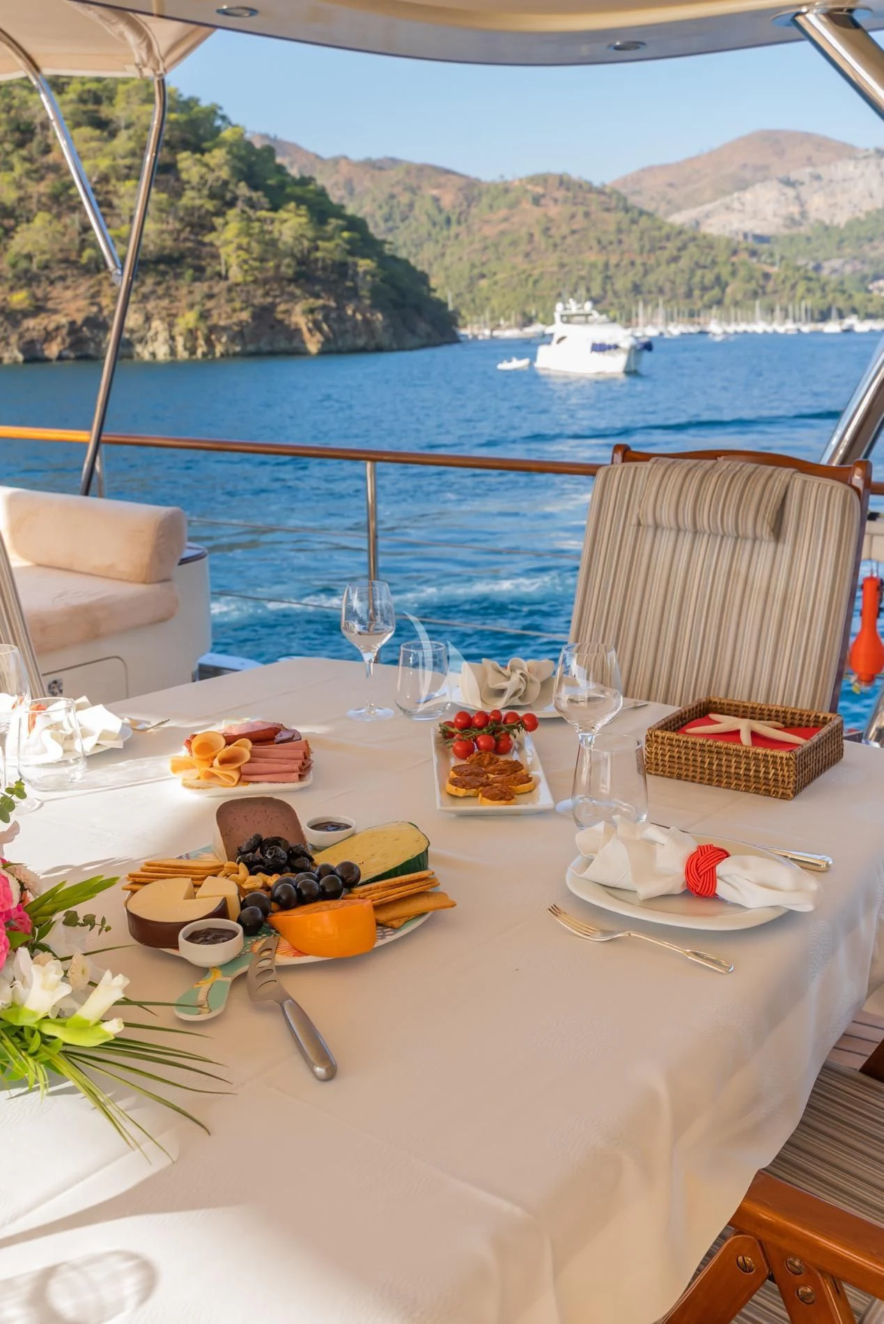 a table with food and glasses on it by a body of water aboard DAIMA Yacht for Sale