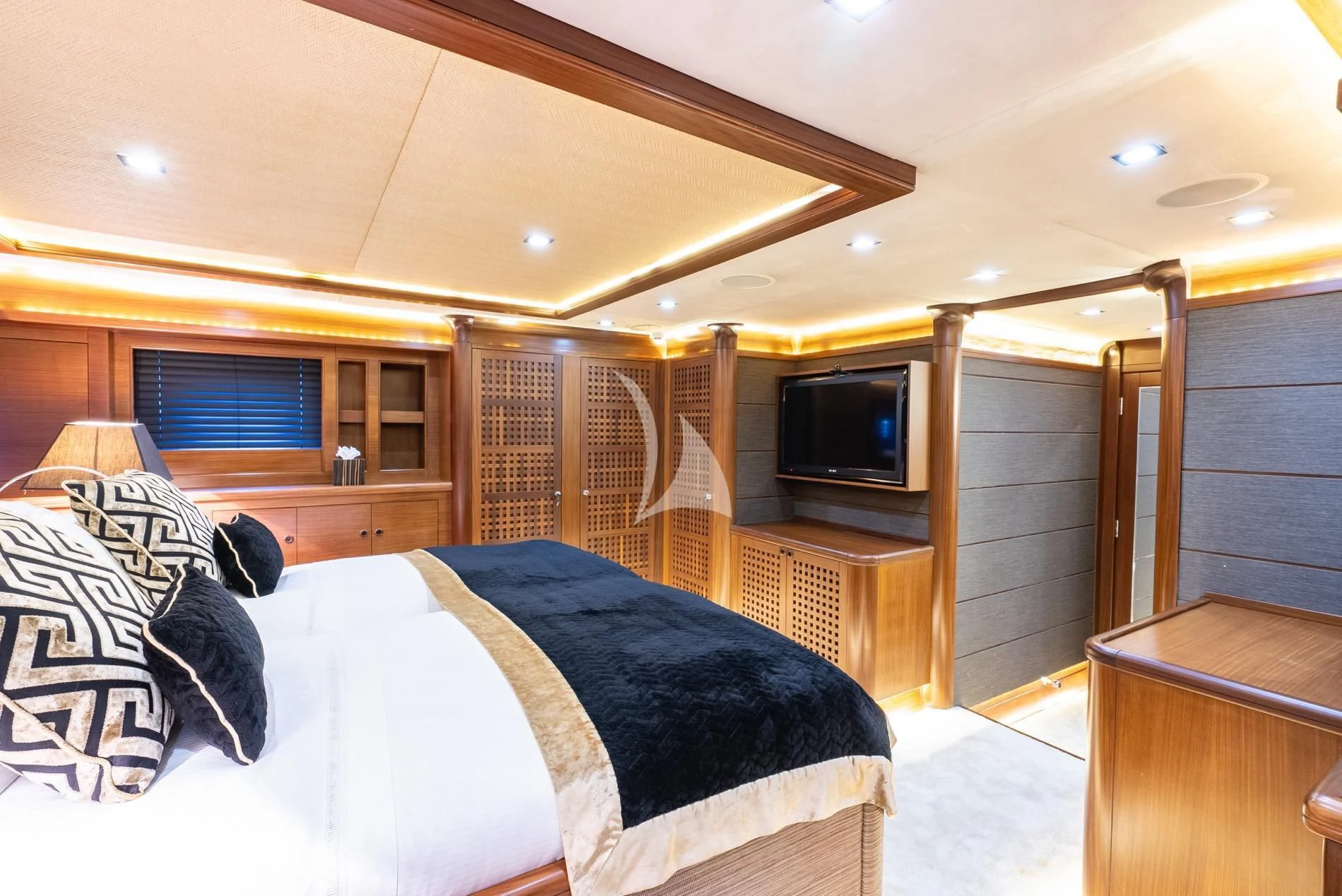 a bedroom with a bed and television aboard DAIMA Yacht for Sale