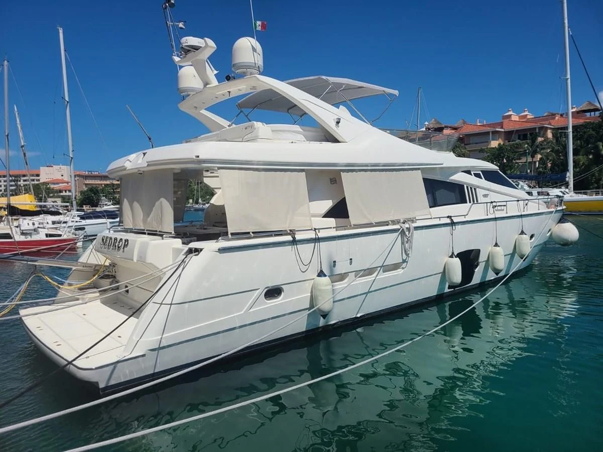 a white boat in a harbor aboard SEDROP - 2006 FERRETTI 731 @ PTO. AVENTURAS Yacht for Sale