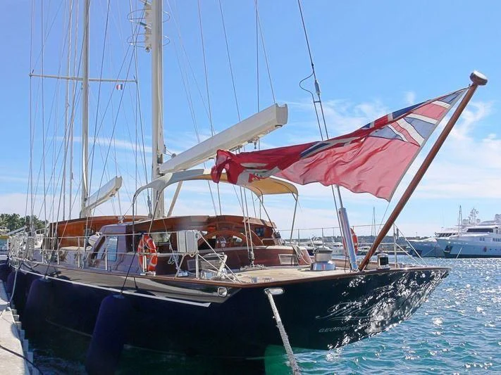 a boat with a red sail aboard THALIA Yacht for Sale