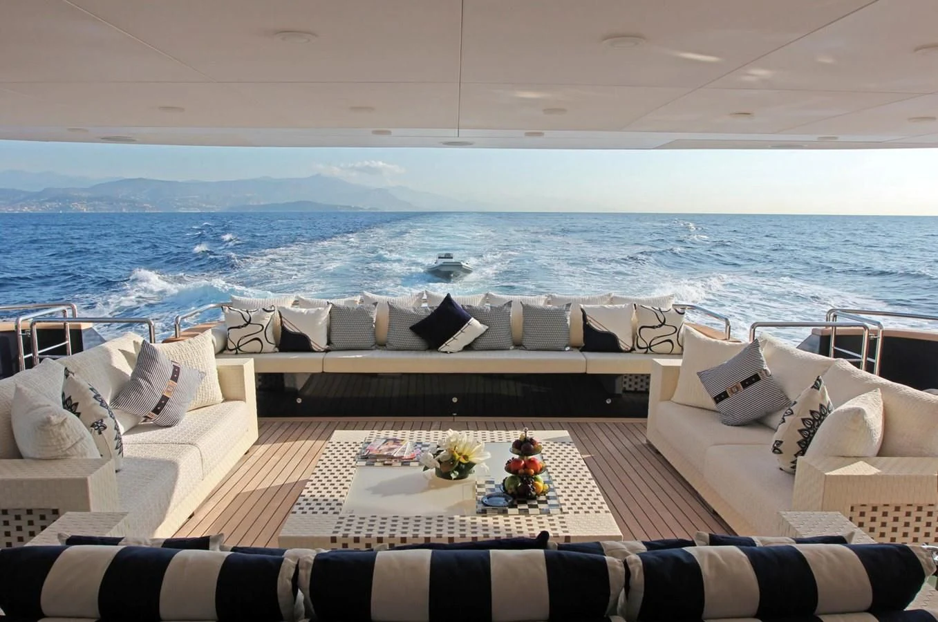 a couch and a table on a balcony overlooking the ocean aboard BURKUT Yacht for Sale