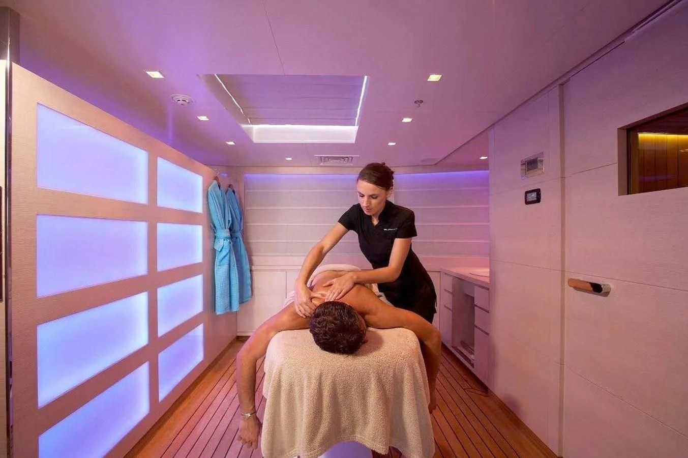 a man holding a woman in a room with white walls aboard BURKUT Yacht for Sale