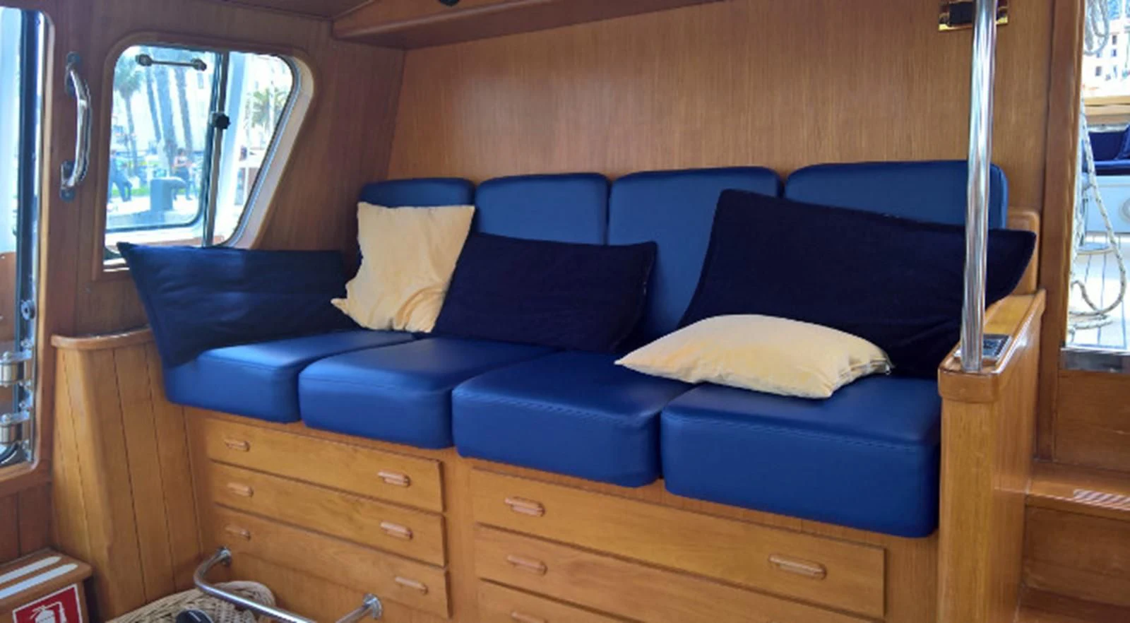 a blue couch with white pillows aboard ACOA Yacht for Sale