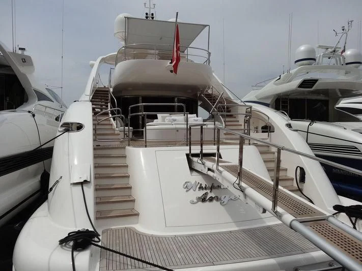 a white boat with a red ribbon on the front aboard WHISPERING ANGEL Yacht for Sale