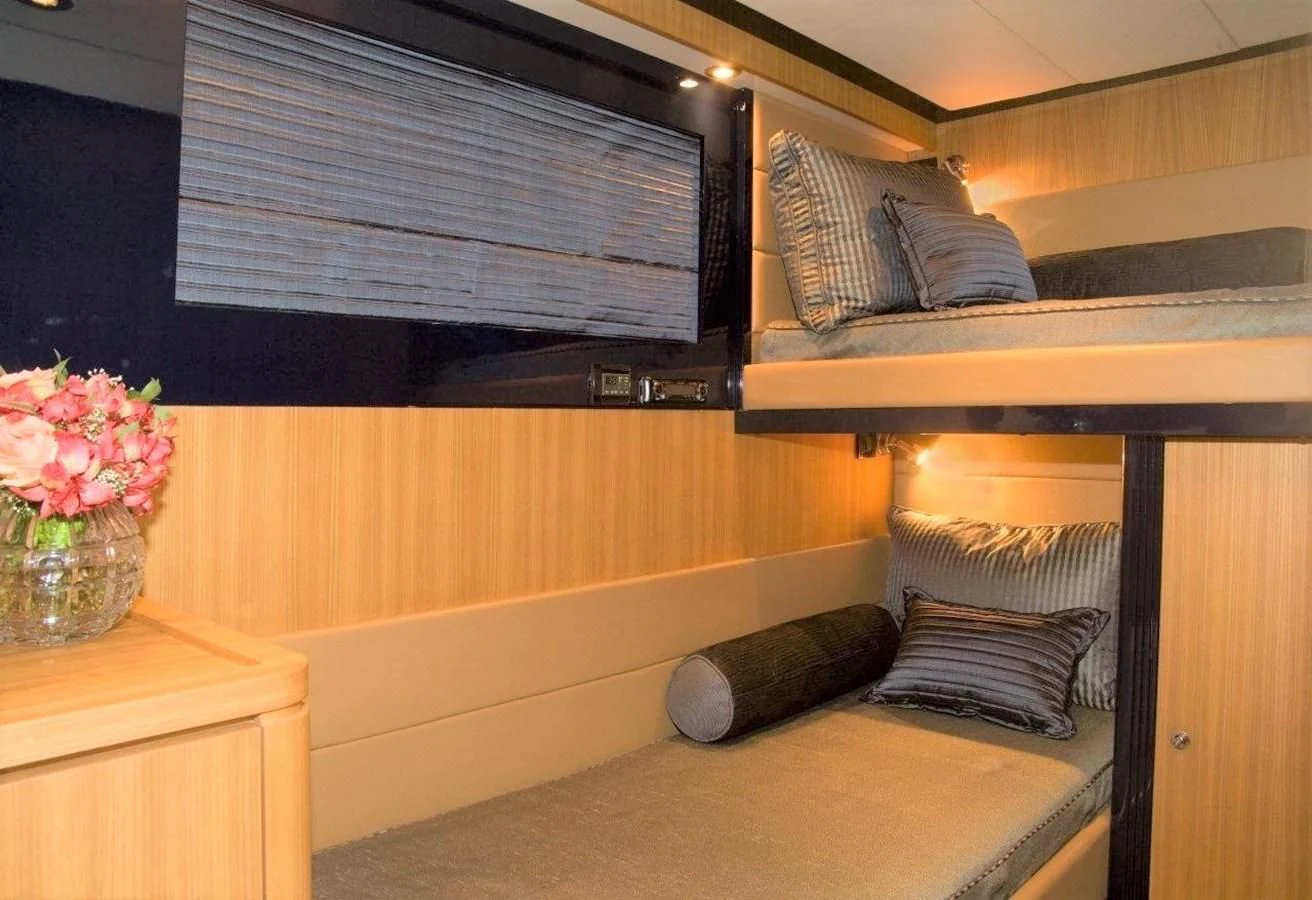 a bed with a wood headboard and a window with a window aboard BON VIVANT Yacht for Sale