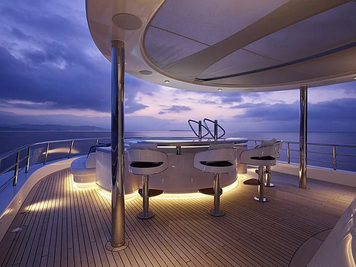 a deck with tables and chairs aboard EXCELLENCE Yacht for Sale