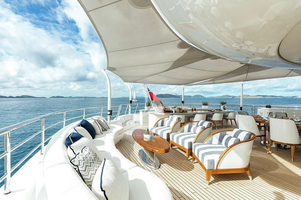 a deck with chairs and tables on it aboard EXCELLENCE Yacht for Sale