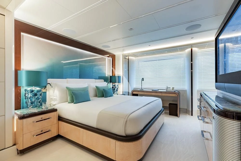 a bedroom with a bed and a desk aboard EXCELLENCE Yacht for Sale