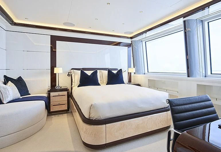 a bedroom with a bed and a chair aboard EXCELLENCE Yacht for Sale