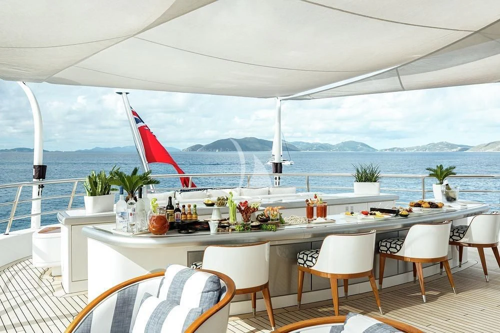 a table with chairs and a flag on it aboard EXCELLENCE Yacht for Sale