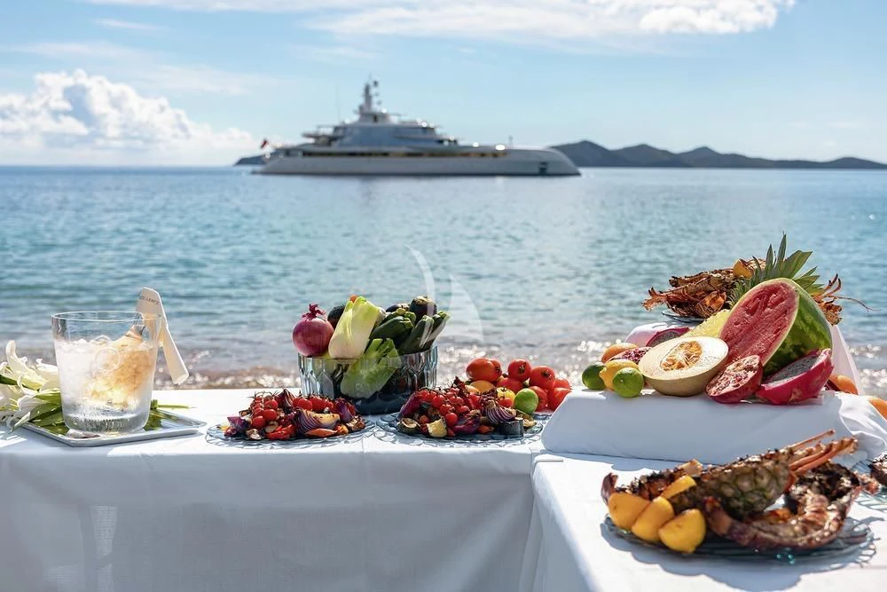 a table with food on it by the water aboard EXCELLENCE Yacht for Sale