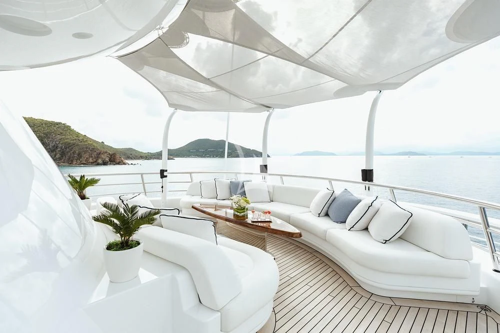 a room with a large white bed and a table with plants aboard EXCELLENCE Yacht for Sale