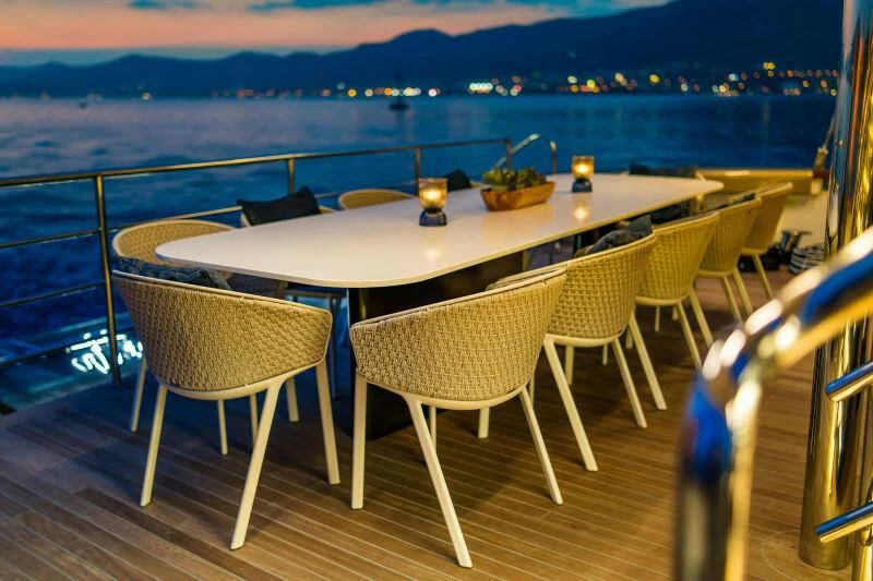 a table with chairs on a deck overlooking a body of water aboard ANETTA Yacht for Charter