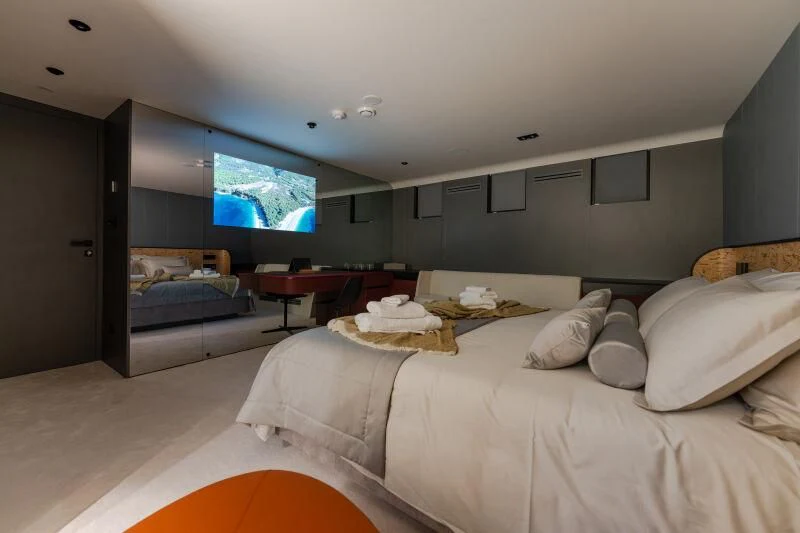 a bedroom with a bed and a tv on the wall aboard ANETTA Yacht for Charter