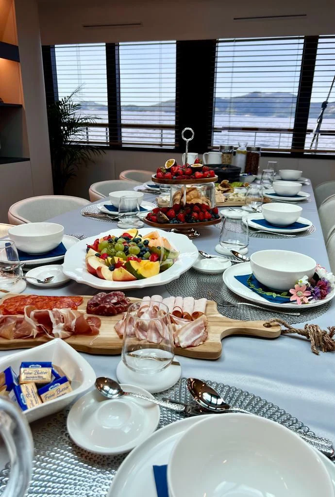 a table with plates and bowls of food on it aboard ANETTA Yacht for Charter