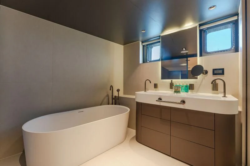 a bathroom with a tub sink and a mirror aboard ANETTA Yacht for Charter