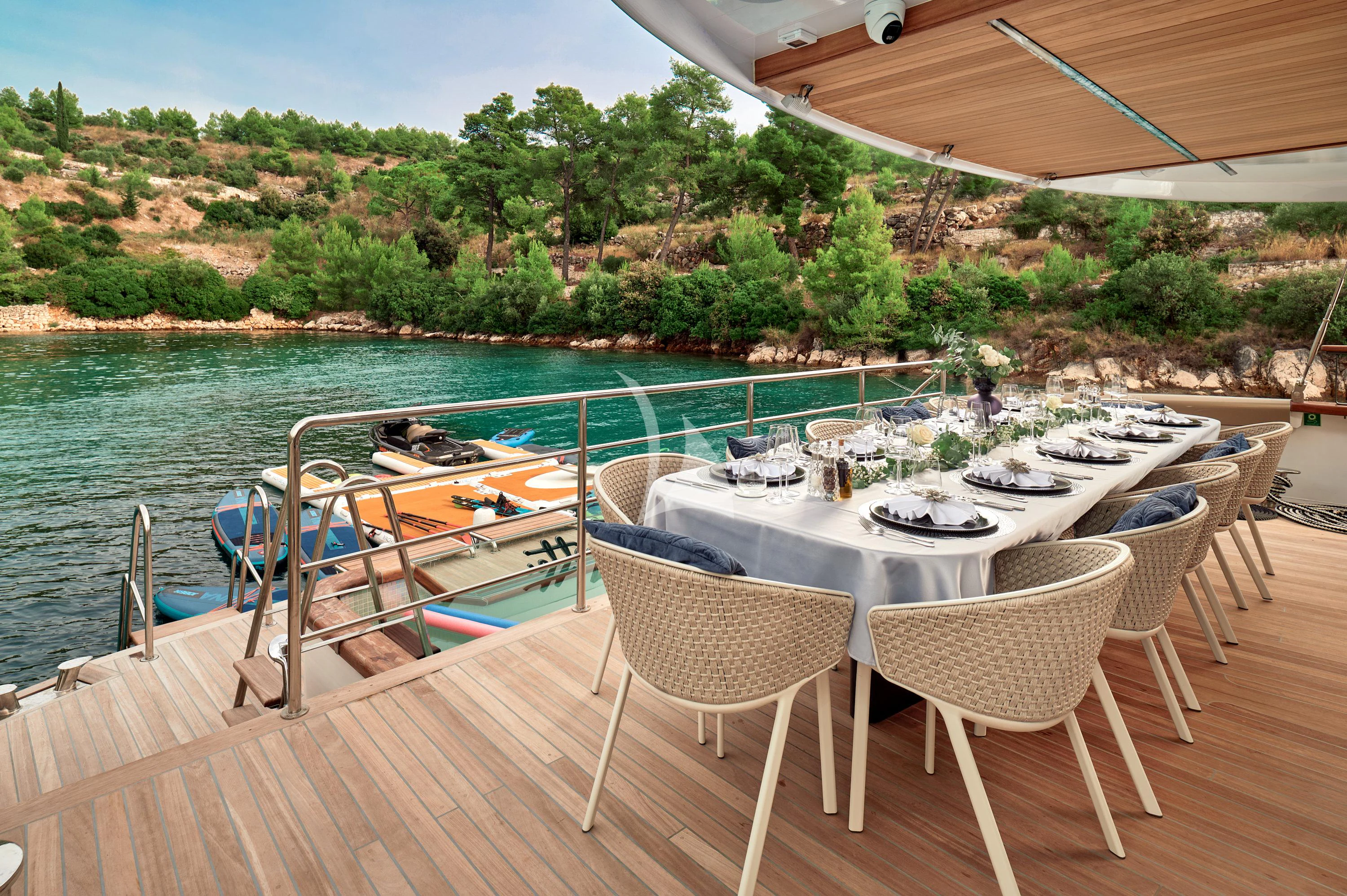 a table set for a meal on a deck overlooking a lake aboard ANETTA Yacht for Charter