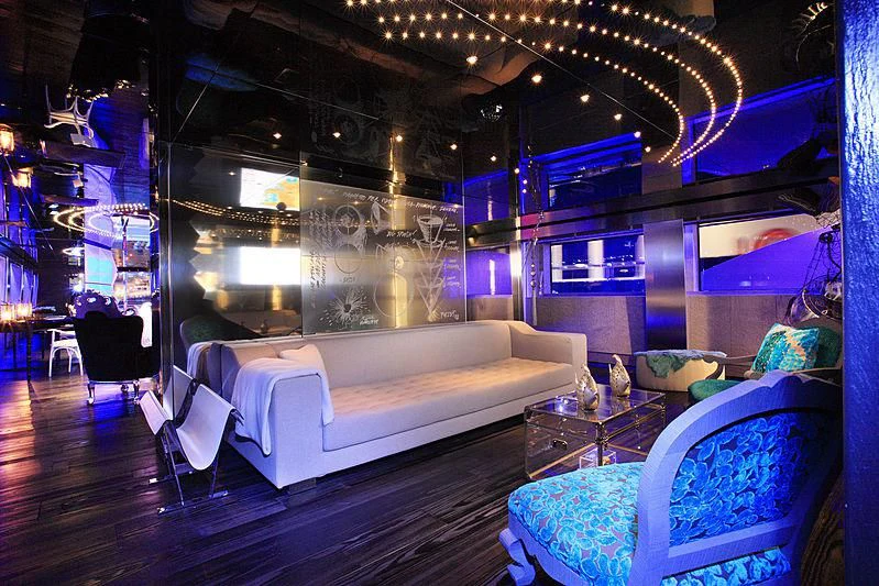 a living room with a couch and a large window aboard MAJESTY ELENOLIYA Yacht for Sale