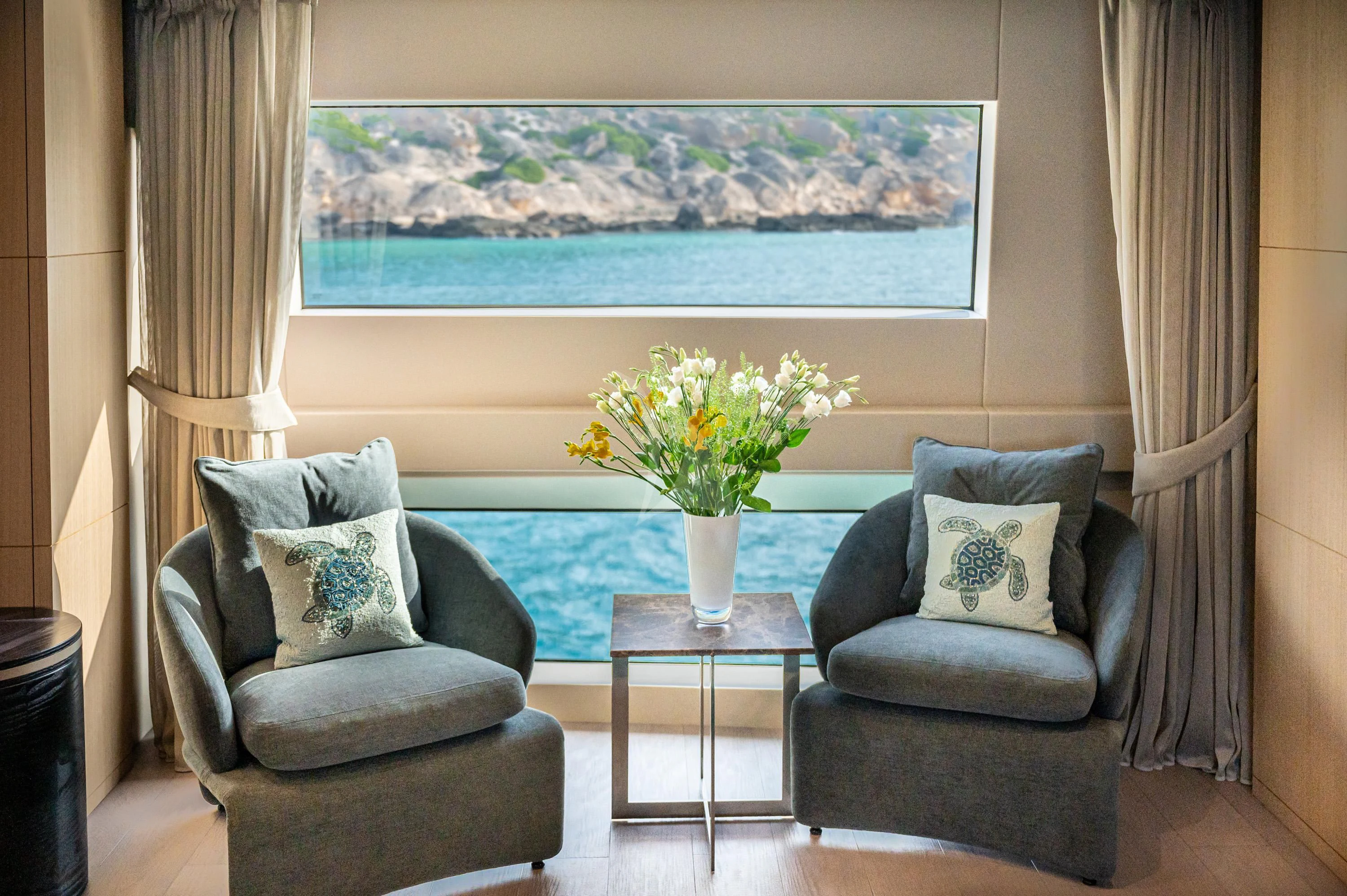 a living room with a large blue table and a large window aboard ALEGRE Yacht for Sale