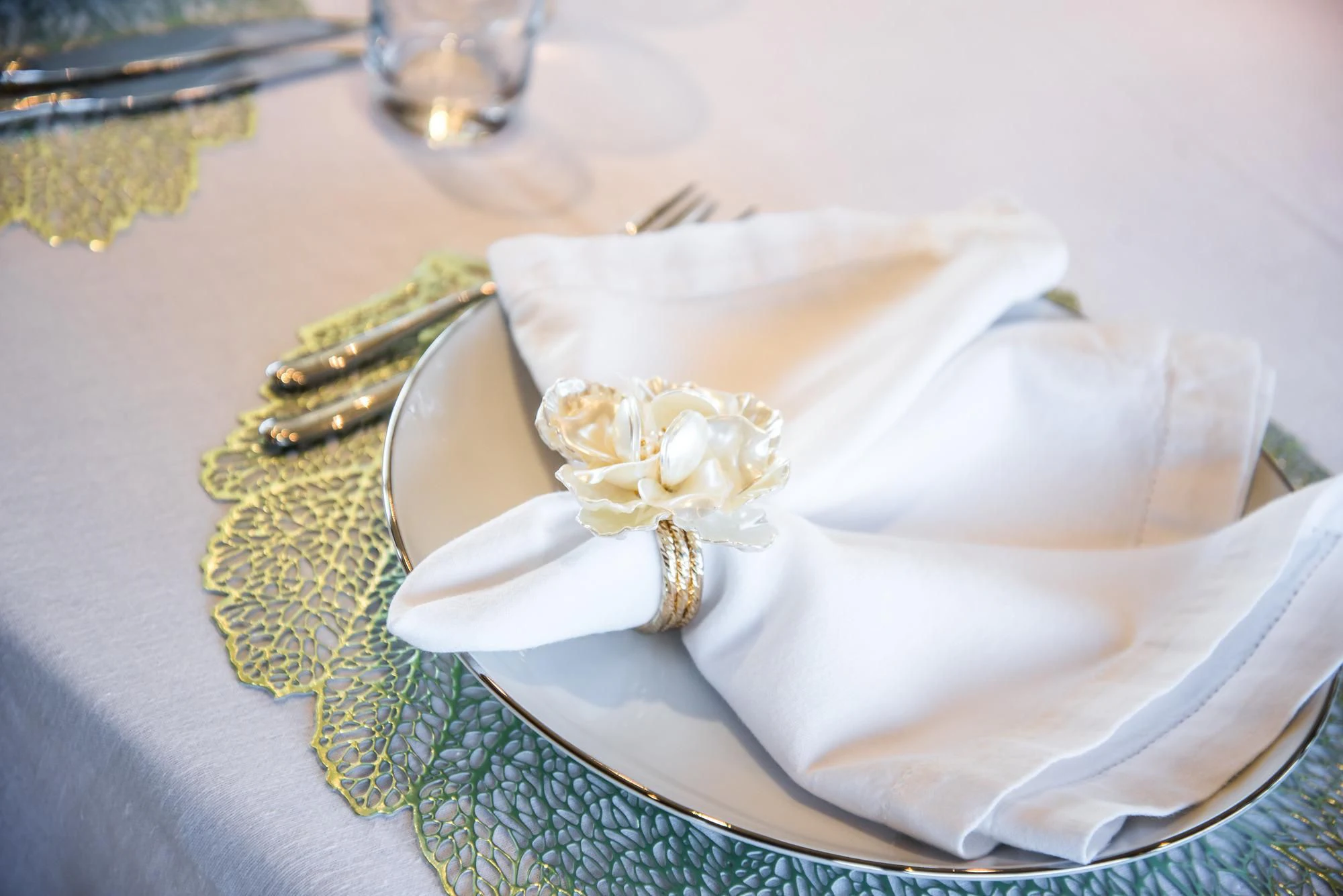 a white flower and a gold ring on a plate aboard QUEEN OF SHEBA Yacht for Sale