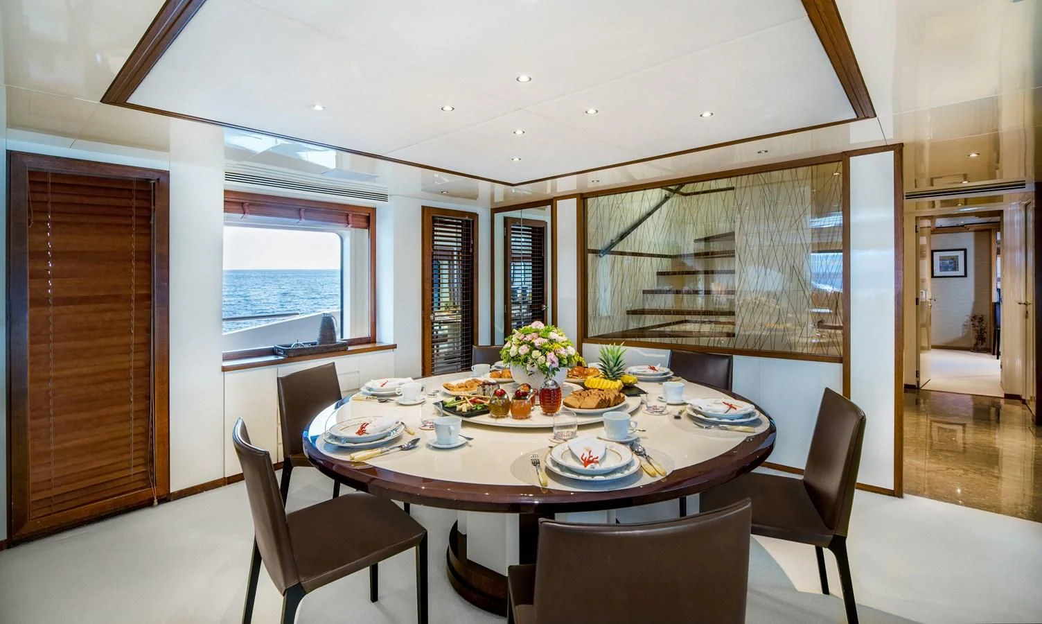 a dining table with plates and chairs aboard IRAVATI Yacht for Sale
