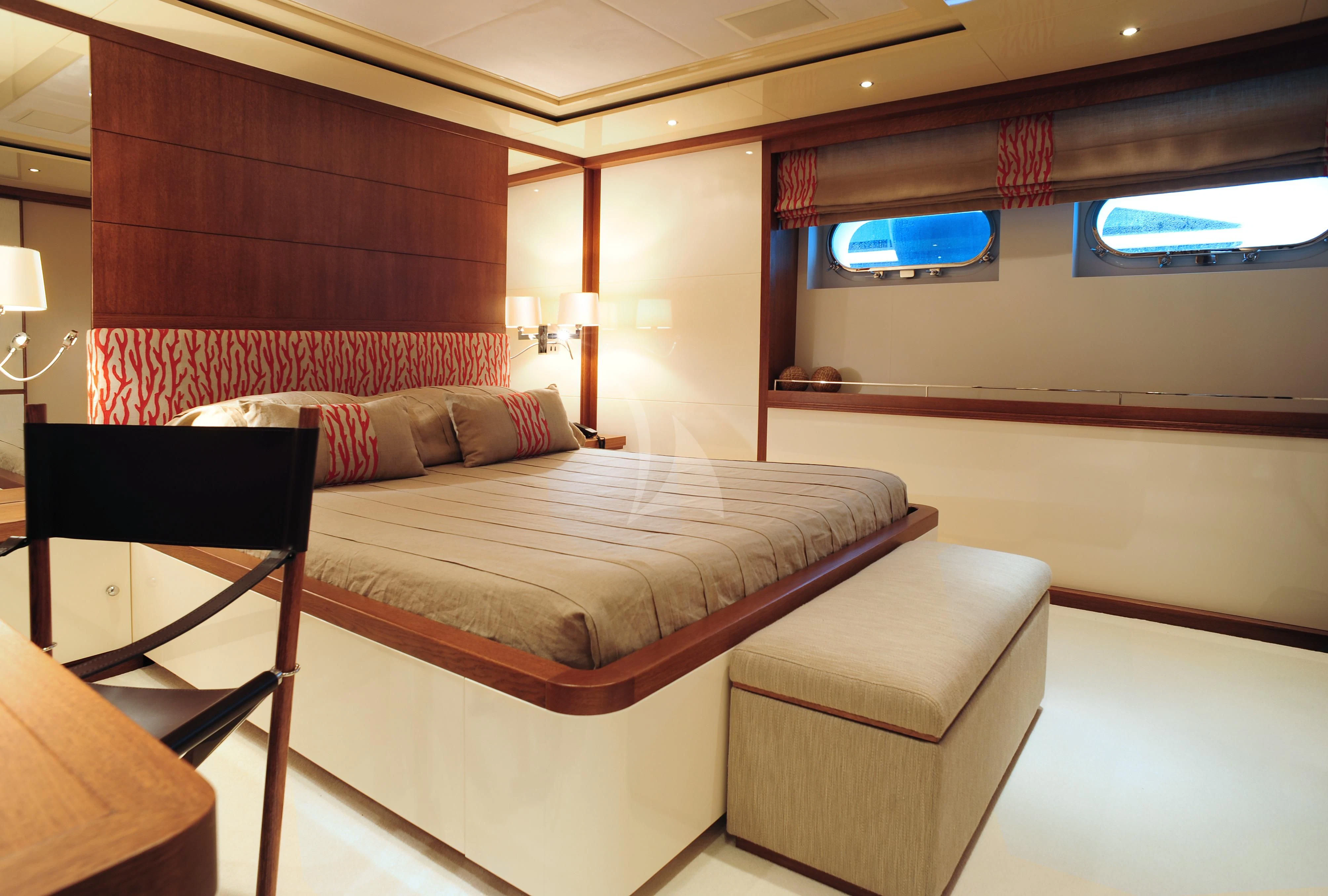 a room with a bed and a chair aboard IRAVATI Yacht for Sale