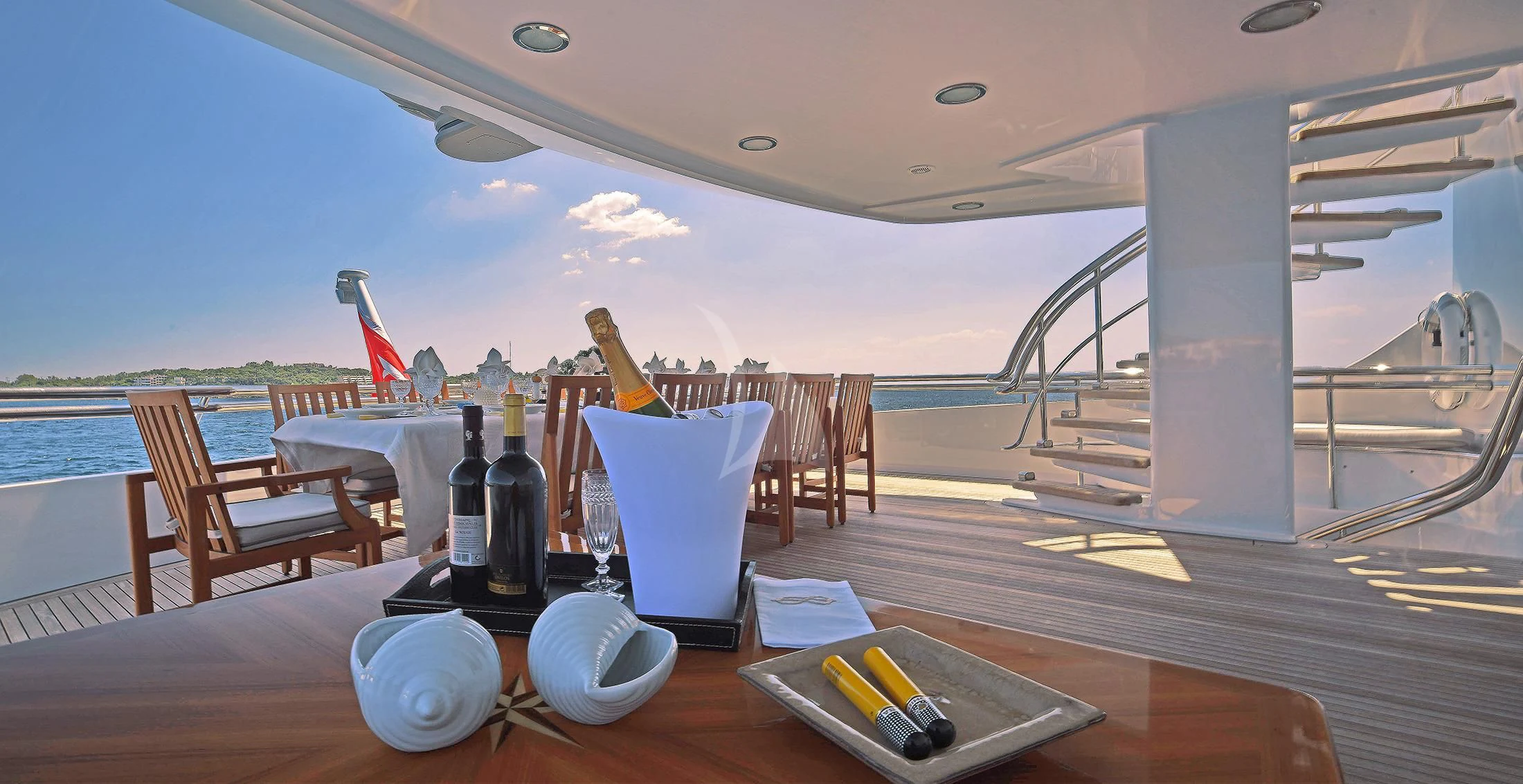 a table with wine bottles and glasses on it aboard IRAVATI Yacht for Sale