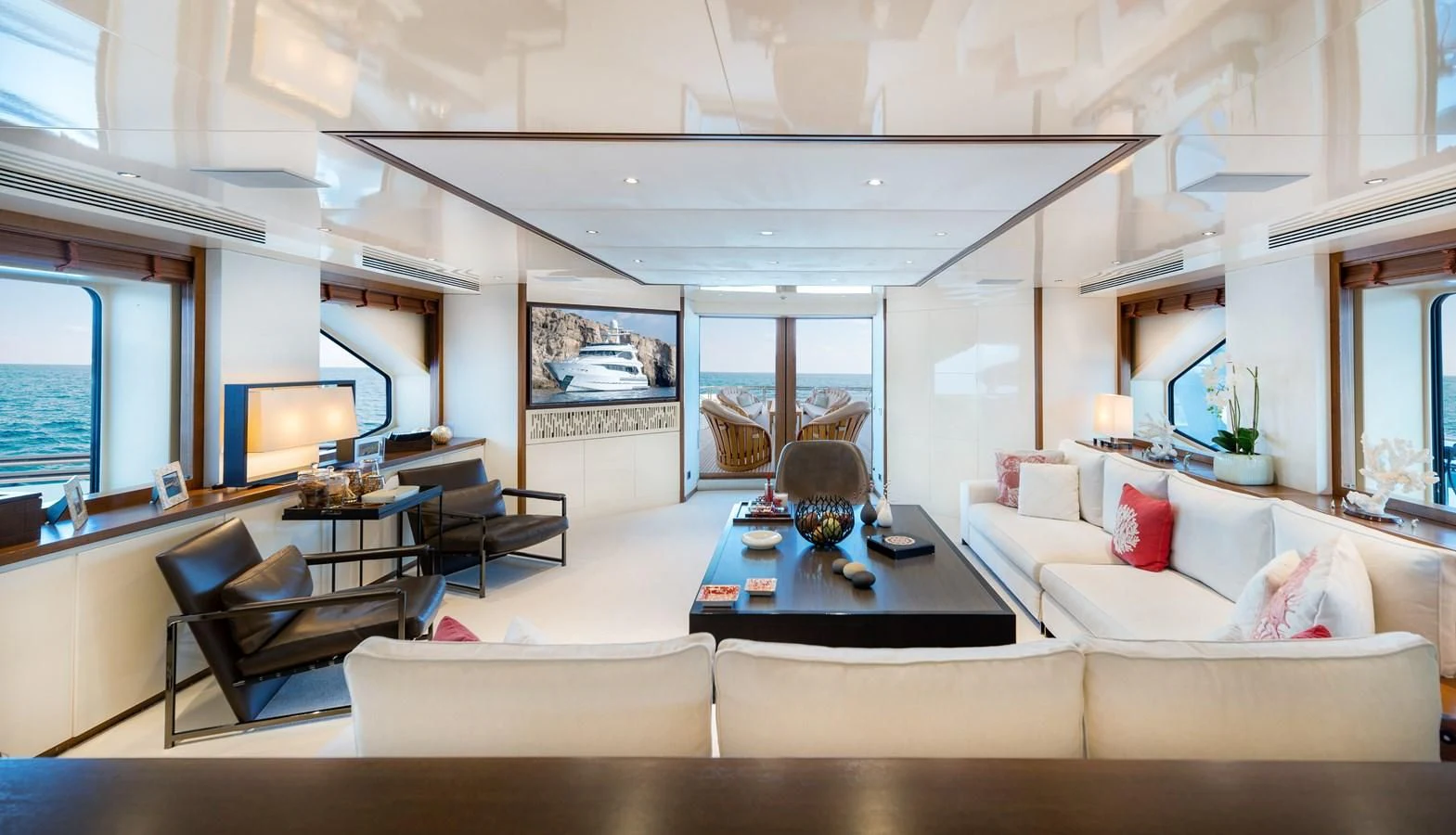 a living room with a table and couches aboard IRAVATI Yacht for Sale